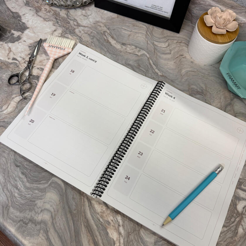 Open view of the dated weekly scheduling layout, showing daily write-in boxes